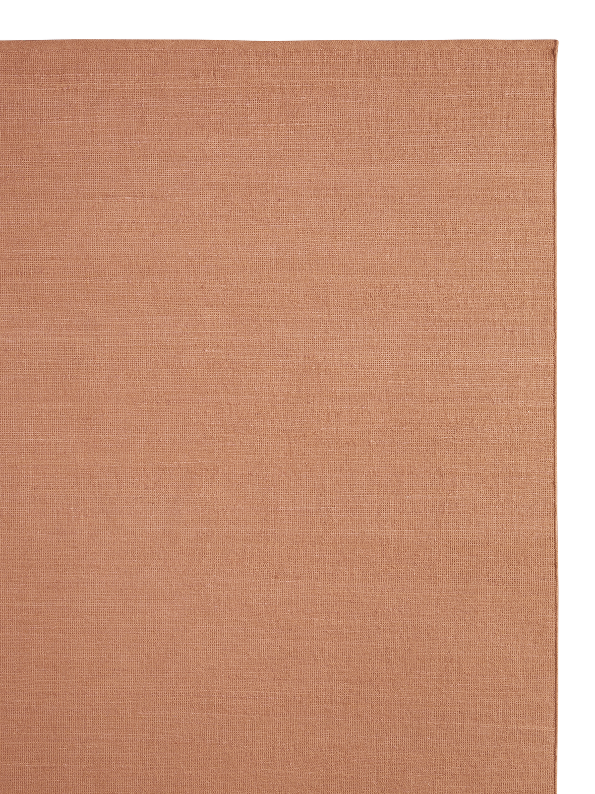 A close-up of a woven rug in a warm, muted orange-brown color, showing the texture and a slight edge | Armadillo Aerie Rug